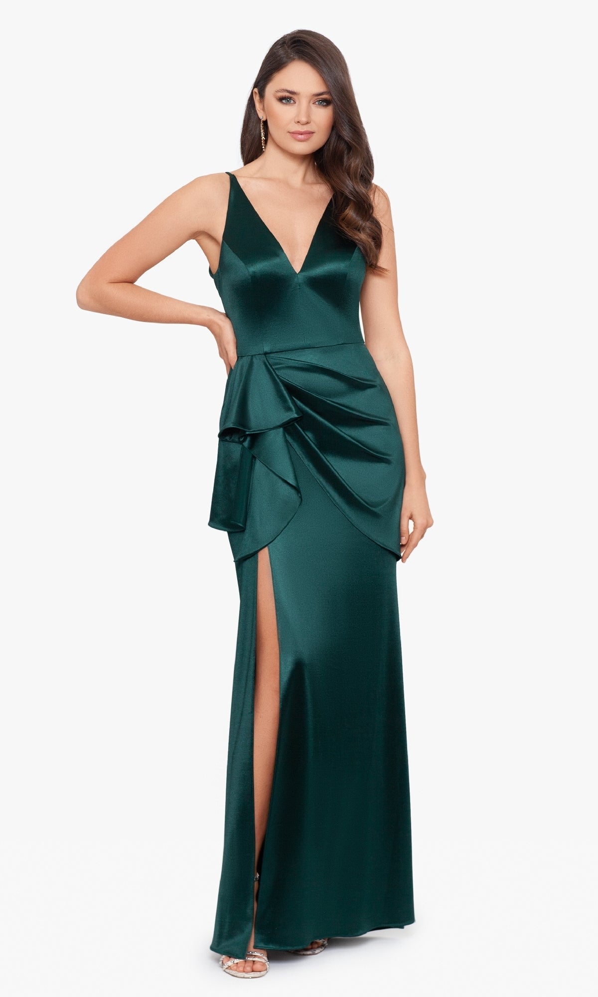 Woman wearing the Blondie Nites Side Drape Long Formal Dress 3458BN—a deep green satin, sleeveless gown with v-neckline, side drape detail, and thigh-high slit—perfect for prom—paired with silver high-heeled sandals.